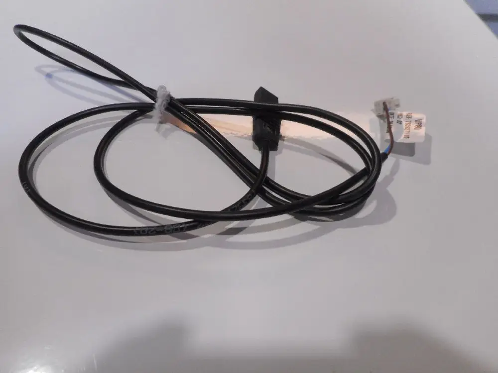 Schwarzes Kabel mit mehreren Leitungen, möglicherweise für eine Verbindung in einem Heizsystem. Zu erkennen sind zwei Anschlussstücke. Teil eines Remeha Produkts.